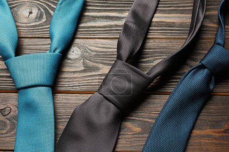 Different neckties on wooden table, flat lay