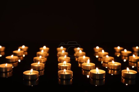 Téléchargez les photos : Brûler des bougies sur la surface du miroir dans l'obscurité - en image libre de droit