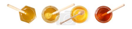 Natural honey in glass jars and dippers isolated on white, top view