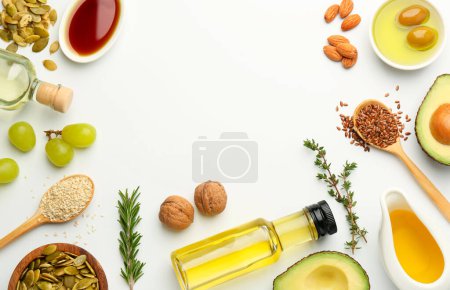 Foto de Grasas vegetales. Diferentes aceites en botellas de vidrio e ingredientes en la mesa blanca, la puesta plana. Espacio para texto - Imagen libre de derechos