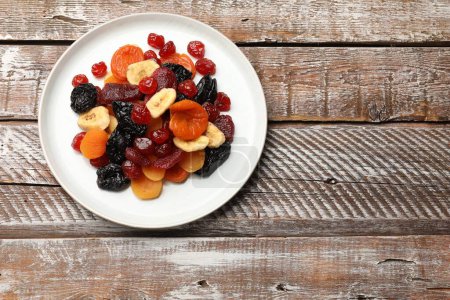 Téléchargez les photos : Mélange de délicieux fruits secs sur une table en bois, vue sur le dessus. Espace pour le texte - en image libre de droit
