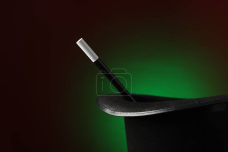 Magician's hat and wand on dark background, space for text