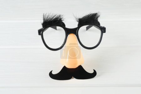 Téléchargez les photos : Masque drôle avec fausse moustache, nez et lunettes sur fond blanc en bois, vue de dessus - en image libre de droit