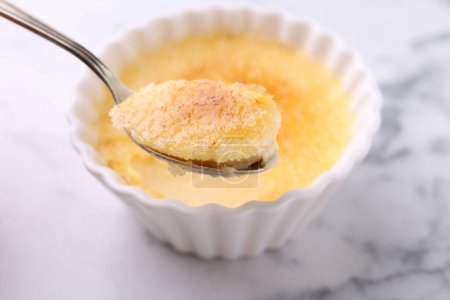 Foto de Comer deliciosa crema brulee en la mesa de mármol blanco, primer plano - Imagen libre de derechos