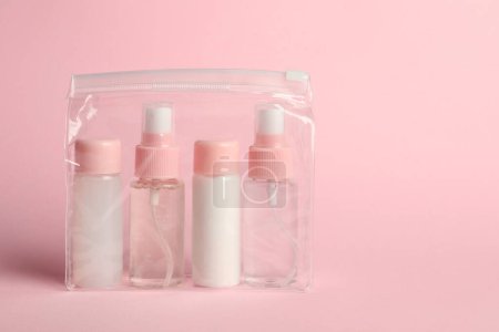 Téléchargez les photos : Trousse de voyage cosmétique en sac plastique sur fond rose. Espace pour le texte - en image libre de droit