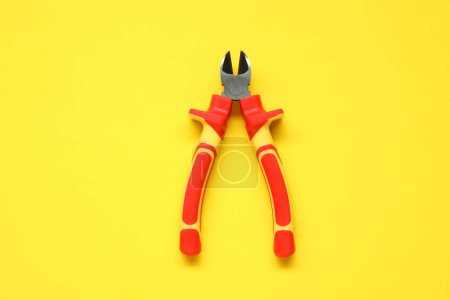 Photo for Diagonal pliers on yellow background, top view - Royalty Free Image