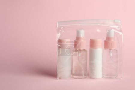 Téléchargez les photos : Trousse de voyage cosmétique en sac plastique sur fond rose. Espace pour le texte - en image libre de droit