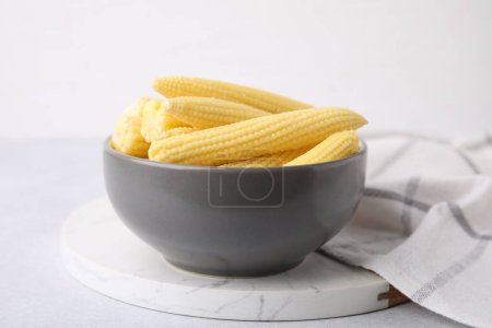 Sabroso maíz fresco amarillo bebé en un tazón sobre una mesa blanca