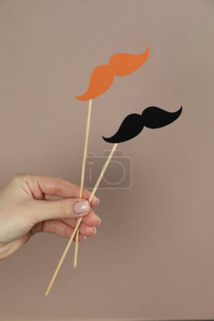 Photo for Woman with fake paper mustaches on beige background, closeup - Royalty Free Image