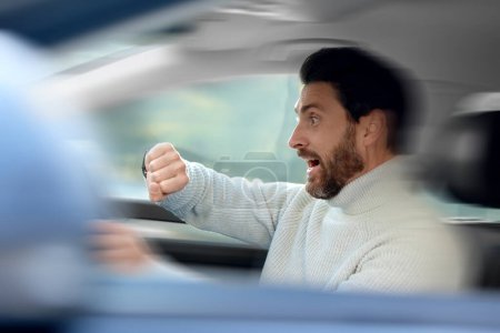 Zu spät. Gestresster Mann kontrolliert Zeit im Auto Bewegungsunschärfeeffekt