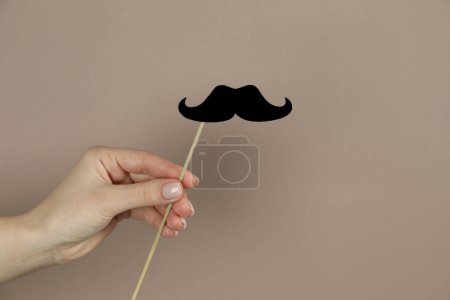 Téléchargez les photos : Femme avec une fausse moustache en papier sur fond beige, gros plan. Espace pour le texte - en image libre de droit