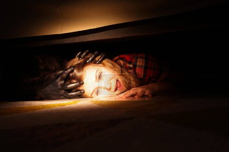 Photo for Childhood phobia. Little girl with monster under bed at home, closeup - Royalty Free Image