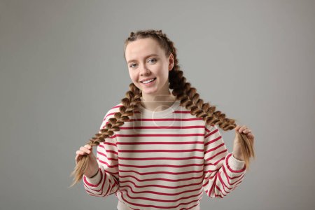Foto de Mujer con cabello trenzado sobre fondo gris - Imagen libre de derechos