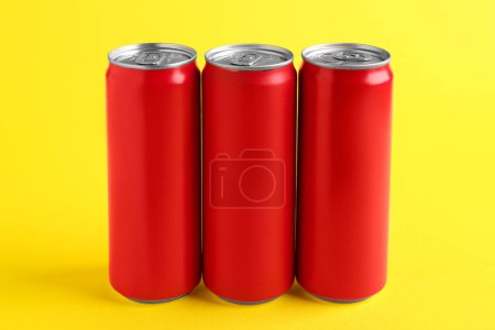 Foto de Bebidas energéticas en latas rojas sobre fondo amarillo - Imagen libre de derechos