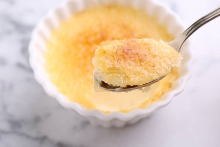 Foto de Comer deliciosa crema brulee en la mesa de mármol blanco, primer plano - Imagen libre de derechos