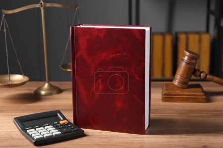 Foto de Derecho fiscal. Libro, calculadora, escamas y mazo sobre mesa de madera - Imagen libre de derechos