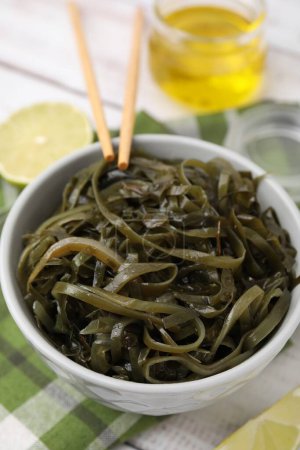 Tasty seaweed salad in bowl served on table, closeup