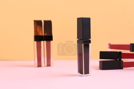 Foto de Muchos diferentes brillos labiales en el fondo de color - Imagen libre de derechos