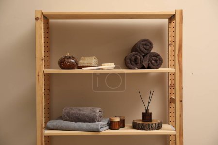 Soft towels, candles, air freshener and spa products on shelves indoors