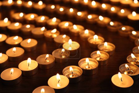 Téléchargez les photos : Brûler des bougies sur une table en bois dans l'obscurité - en image libre de droit