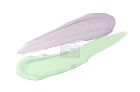 Strokes of green and purple color correcting concealers isolated on white, top view