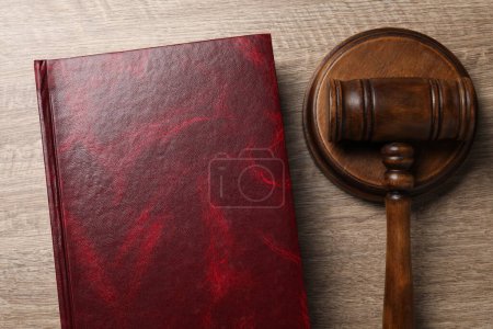 Law. Book and gavel on wooden table, top view