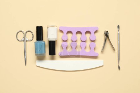 Foto de Esmaltes de uñas y conjunto de herramientas de pedicura sobre fondo beige, planas - Imagen libre de derechos