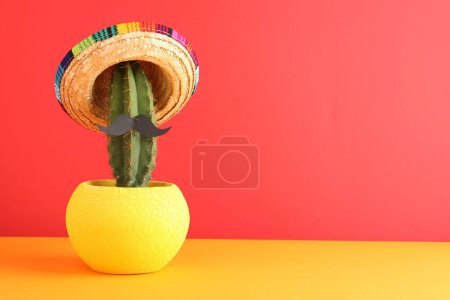 Téléchargez les photos : Cactus avec chapeau de sombrero mexicain et fausse moustache sur fond de couleur. Espace pour le texte - en image libre de droit