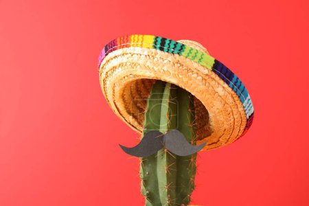 Téléchargez les photos : Cactus avec chapeau de sombrero mexicain et fausse moustache sur fond rouge - en image libre de droit