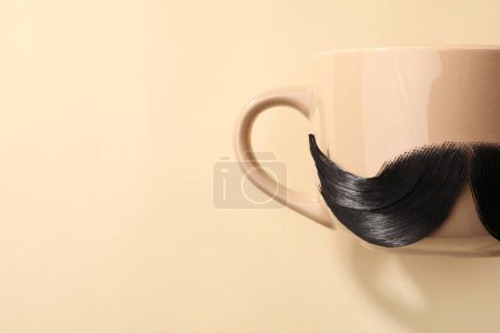 Téléchargez les photos : Moustache artificielle et tasse sur fond beige, vue de dessus. Espace pour le texte - en image libre de droit