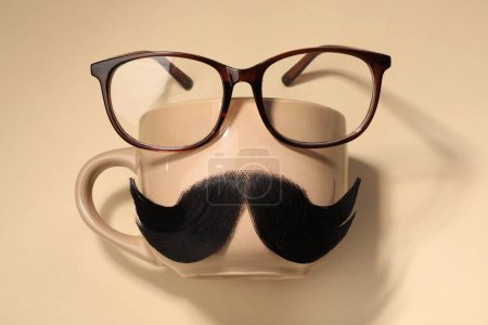 Téléchargez les photos : Moustache artificielle, tasse et verres sur fond beige, vue de dessus - en image libre de droit