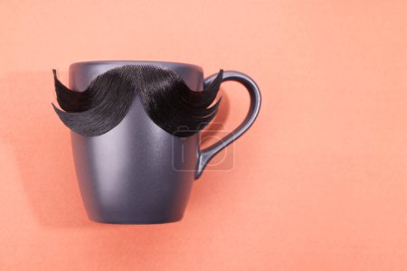 Téléchargez les photos : Visage d'homme fait de moustache artificielle et tasse sur fond rose, vue de dessus. Espace pour le texte - en image libre de droit
