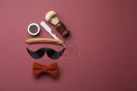 Téléchargez les photos : Moustache artificielle et outils de coiffeur sur fond bordeaux, pose plate. Espace pour le texte - en image libre de droit