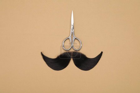 Téléchargez les photos : Moustache artificielle et ciseaux sur fond beige, vue de dessus - en image libre de droit