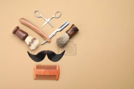 Téléchargez les photos : Moustache artificielle et outils de coiffeur sur fond beige, pose plate. Espace pour le texte - en image libre de droit