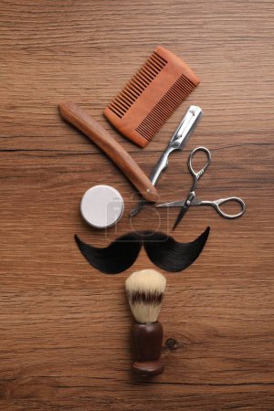 Téléchargez les photos : Moustache artificielle et outils de barbier sur table en bois, pose plate - en image libre de droit