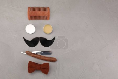 Téléchargez les photos : Moustache artificielle et outils de barbier sur table grise, pose plate. Espace pour le texte - en image libre de droit