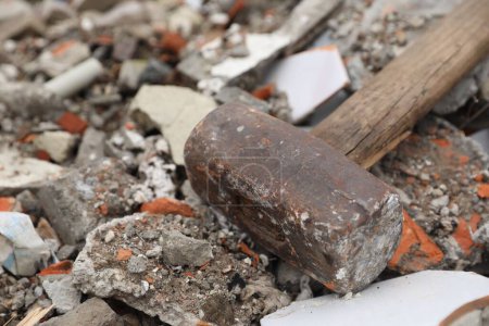 Sledgehammer on pile of broken bricks, closeup