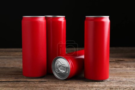 Foto de Bebidas energéticas en latas rojas sobre mesa de madera - Imagen libre de derechos
