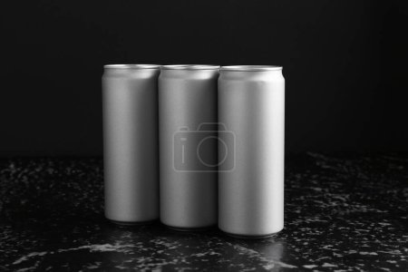 Foto de Bebidas energéticas en latas sobre mesa texturizada negra - Imagen libre de derechos