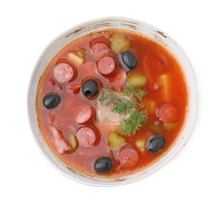 Téléchargez les photos : Soupe de viande solyanka avec de fines saucisses fumées sèches dans un bol isolé sur blanc, vue sur le dessus - en image libre de droit