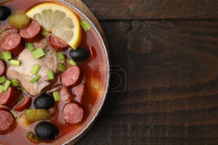 Téléchargez les photos : Soupe de viande solyanka avec de fines saucisses fumées sèches dans un bol sur une table en bois, vue sur le dessus. Espace pour le texte - en image libre de droit
