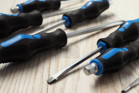 Set of screwdrivers on white wooden table, closeup