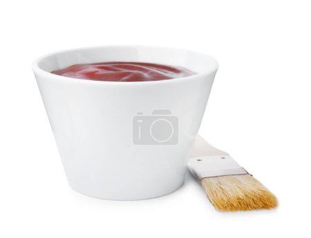 Marinade in bowl and basting brush isolated on white