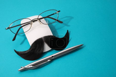 Téléchargez les photos : Composition avec moustache artificielle et verres sur fond bleu clair, espace pour le texte - en image libre de droit