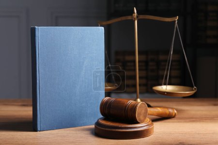 Law. Book, gavel and scales on wooden table