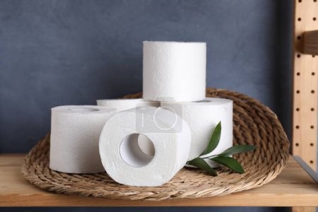 Téléchargez les photos : Rouleaux de papier toilette et feuilles vertes sur étagère en bois - en image libre de droit