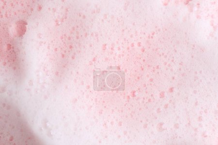 Mousse duveteuse blanche sur fond rose, vue de dessus
