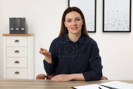Foto de Mujer teniendo video chat en la mesa de madera en la oficina, vista desde la cámara web - Imagen libre de derechos