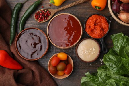 Different marinades and products on wooden table, flat lay